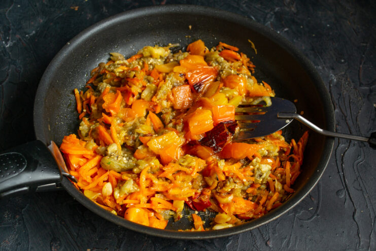 Incorporating Roasted Bell Pepper for a Sweet and Smoky Flavor Chopped roasted bell pepper being added to the ragout in the skillet.