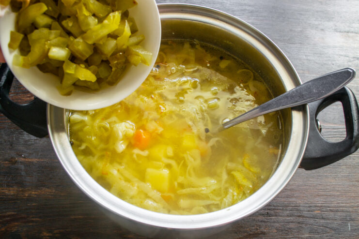 The Secret to Rassolnik: Adding Pickles and Brine Diced pickles and pickle brine being added to the soup pot.