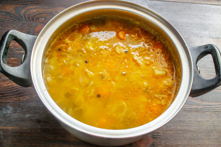 Final Simmer: Letting the Flavors Meld Together The finished Rassolnik soup simmering in a pot for the final few minutes.