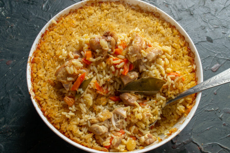 The final result: a perfectly cooked, fluffy oven-baked chicken plov. A close-up of the finished fluffy chicken plov in the baking dish after coming out of the oven.