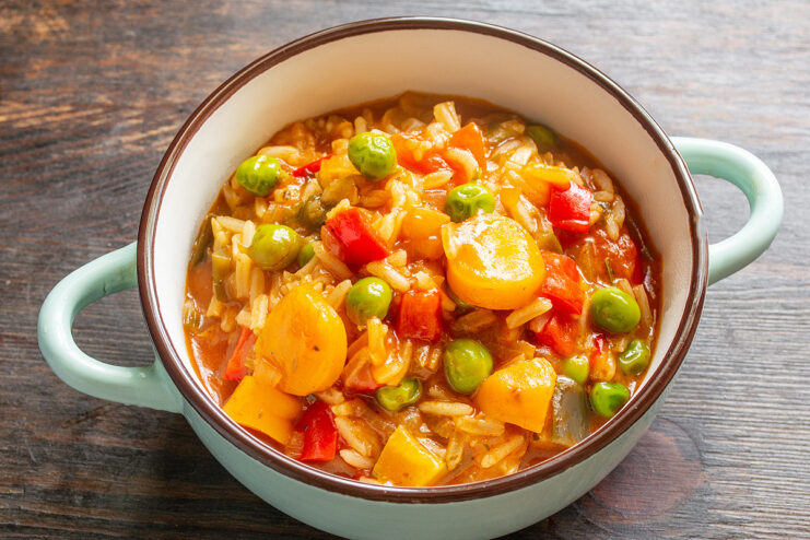A delicious, hot serving of Ratatouille with Rice ready to be enjoyed. A bowl of hot, freshly cooked ratatouille with rice, ready to be served.