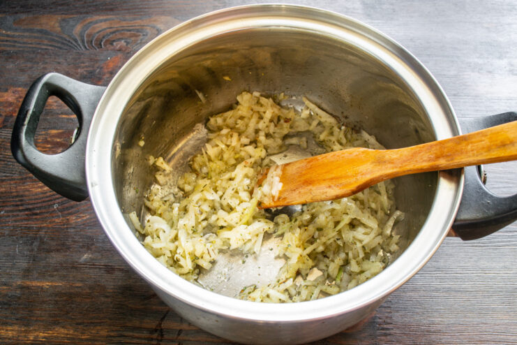 Sautéing onions and garlic until soft and translucent to build flavor. Diced onions and garlic being sautéed in olive oil in a heavy-bottomed pot.