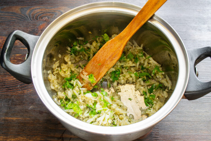Adding freshly chopped celery to the pot for extra aroma and flavor. A pile of finely chopped celery on a cutting board, ready to be added to the stew.