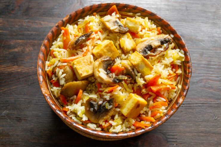 Serving the Finished Rice with Tofu and Mushrooms A final dish of rice with tofu and mushrooms served in a bowl.