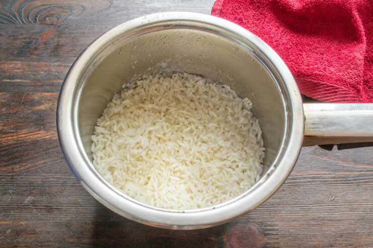 Simmering Rice to Perfection on Low Heat A pot with a lid on a stove, simmering rice on low heat.