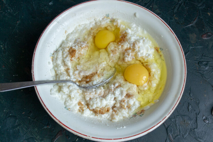 Step 4: Incorporating eggs to bind the casserole ingredients together. Two eggs cracked into the bowl with the rice and ricotta batter.