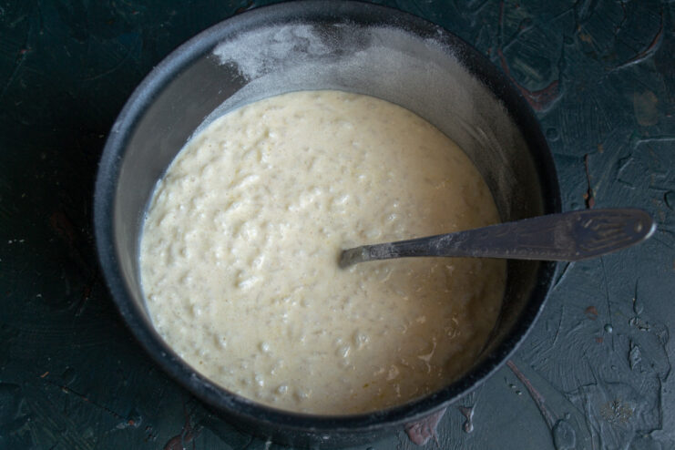Step 6: Pouring the liquid rice and ricotta batter into a prepared baking dish. The liquid casserole batter being poured into a round, non-stick baking dish.