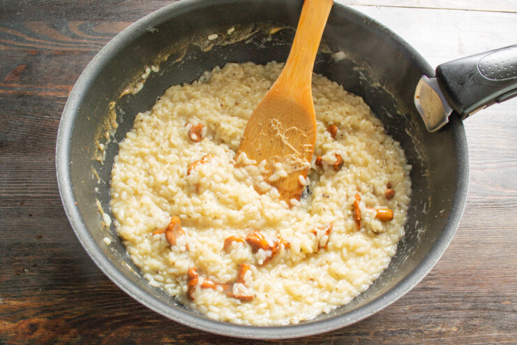 Finishing the Risotto with Grated Parmesan Cheese Stirring freshly grated Parmesan cheese into the creamy mushroom risotto.