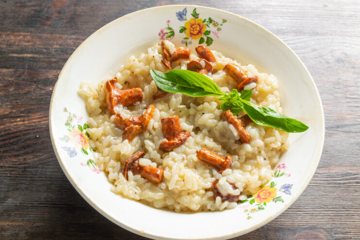 Serving the Perfect Bowl of Homemade Mushroom Risotto A finished plate of mushroom risotto, garnished with Parmesan cheese and fresh basil.