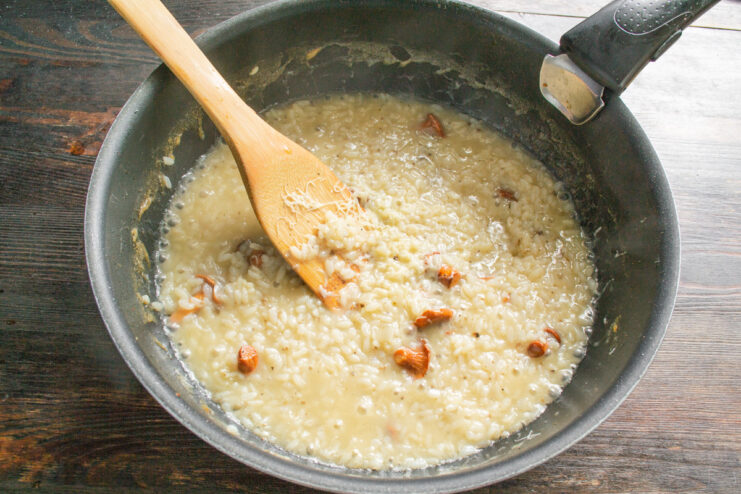 Achieving the Creamy Texture of Risotto by Stirring Close-up of creamy risotto simmering in a skillet, showing the thick, starchy sauce.