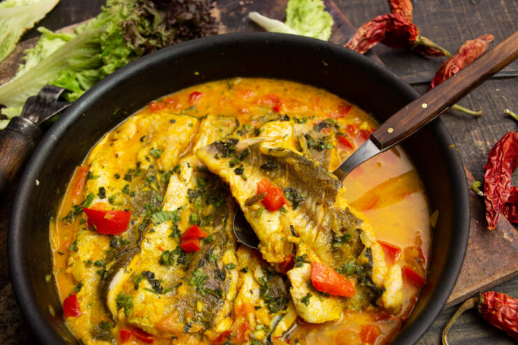 A pan of Moroccan-style fish in a rich red tomato sauce, garnished with fresh cilantro.