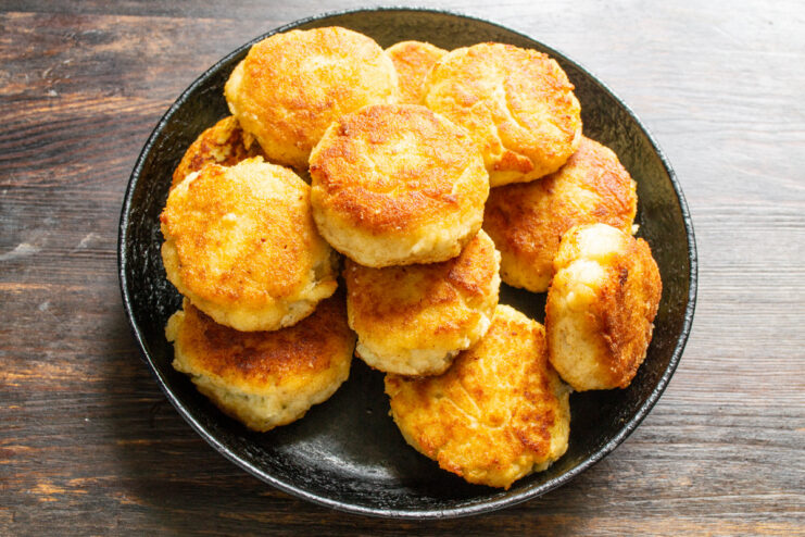 Serving the delicious fish and potato patties with a fresh salad and sauce. A final dish of fish and potato patties served with a side of fresh vegetable salad.