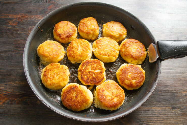 Frying the fish patties until they are perfectly golden and crispy. Fish patties frying in a pan, showing a golden-brown crust.