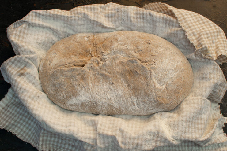 Shaping the Loaf on a Floured Surface Turning the proofed rye dough out onto a floured work surface before shaping.