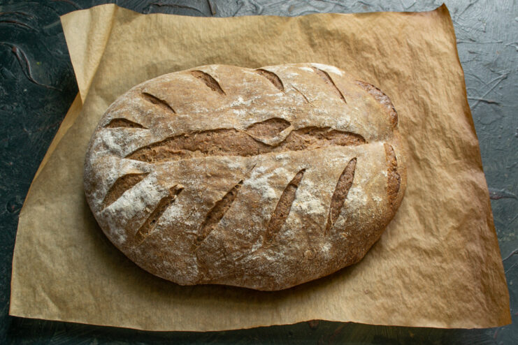 Baking the Rye Bread to Perfection A golden-brown, perfectly baked loaf of sourdough rye bread cooling on a rack.