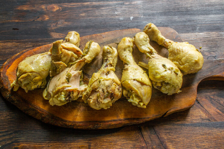 Tip: Cool Chicken in Broth for Maximum Flavor and Juiciness Cooked chicken drumsticks cooling in the pot of broth.