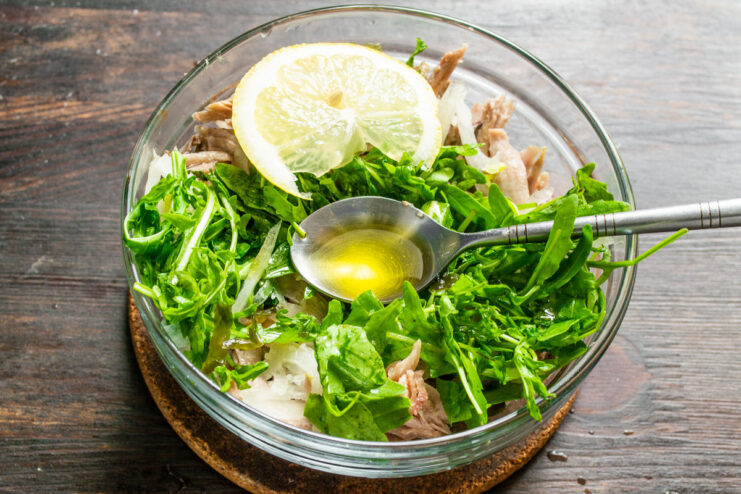 Step 6: Adding Acidity with Lemon Juice or Vinegar Squeezing fresh lemon juice over the seaweed and chicken salad.