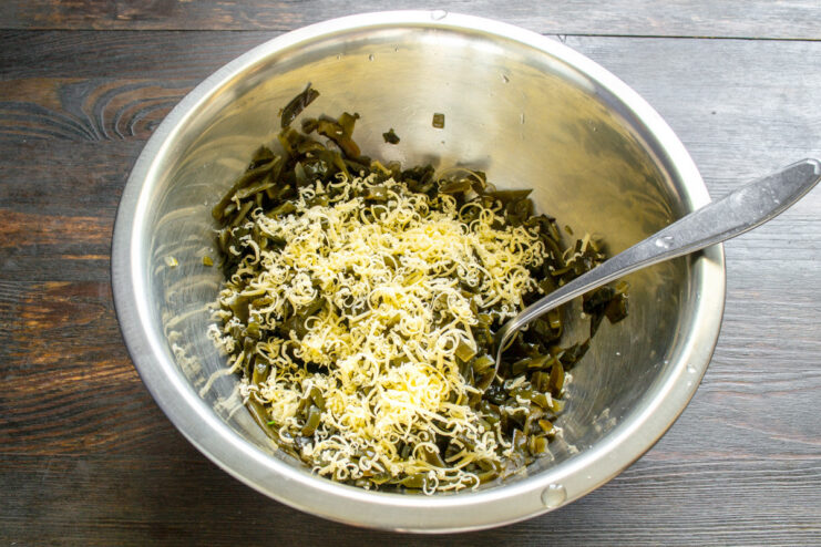 Adding freshly grated cheese for extra flavor Grating a block of hard cheese on a fine metal grater.