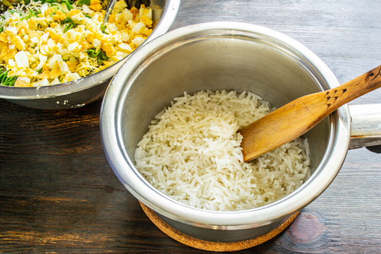 Cooling the cooked rice before adding to the salad A pot of cooked white rice cooling down.