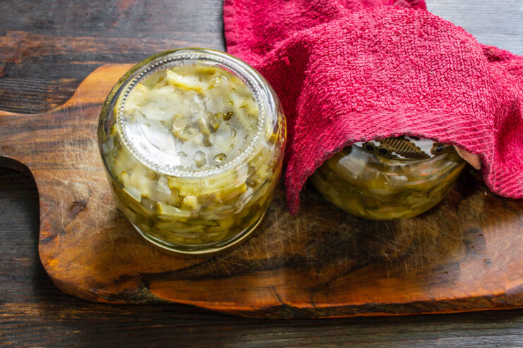 Stock Your Pantry with Homemade Goodness! A beautifully arranged pantry shelf with jars of homemade cucumber and garlic scape salad.
