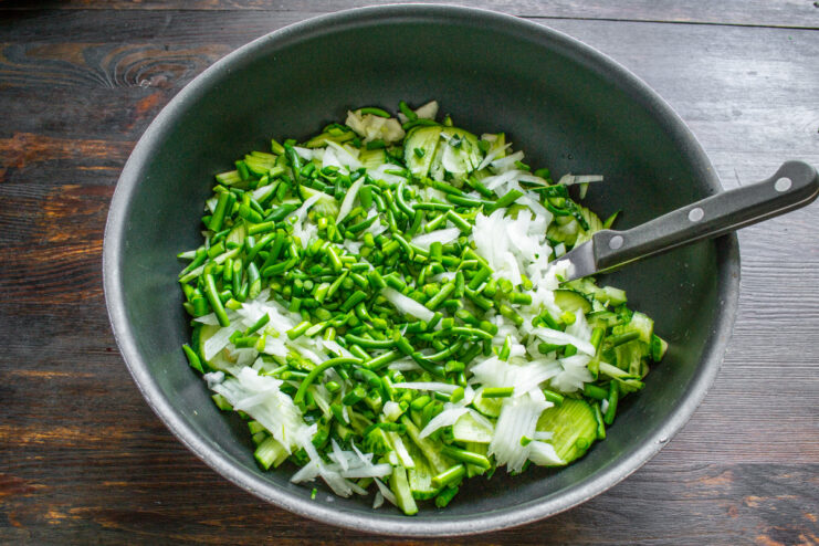 Prepping Garlic Scapes: Washing and Chopping Freshly washed and finely chopped garlic scapes in a bowl, ready for the salad.