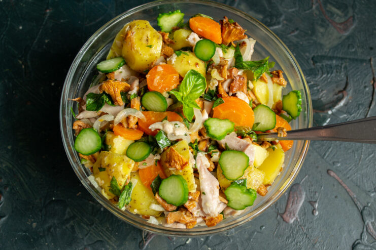 Serving the Warm Chicken and Mushroom Salad The finished chicken and mushroom salad in a serving bowl, garnished with cucumber and basil.