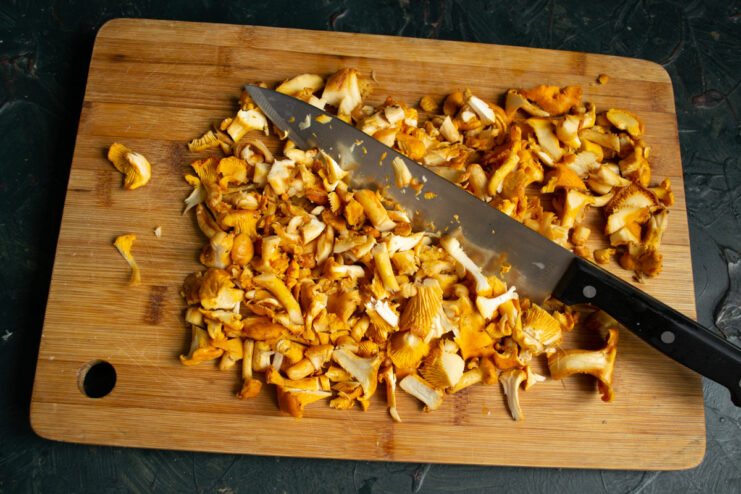 Chopping Chanterelles for the Salad Finely chopped chanterelle mushrooms on a cutting board.