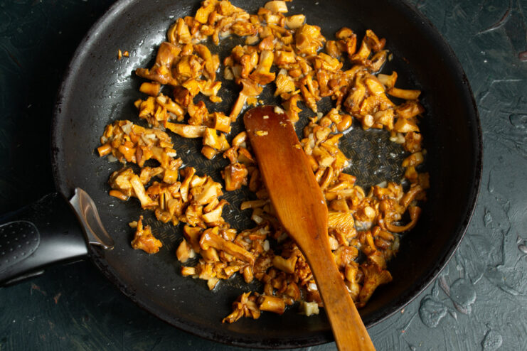 Sautéing Mushrooms and Garlic Chopped chanterelles and garlic being sautéed in a skillet.