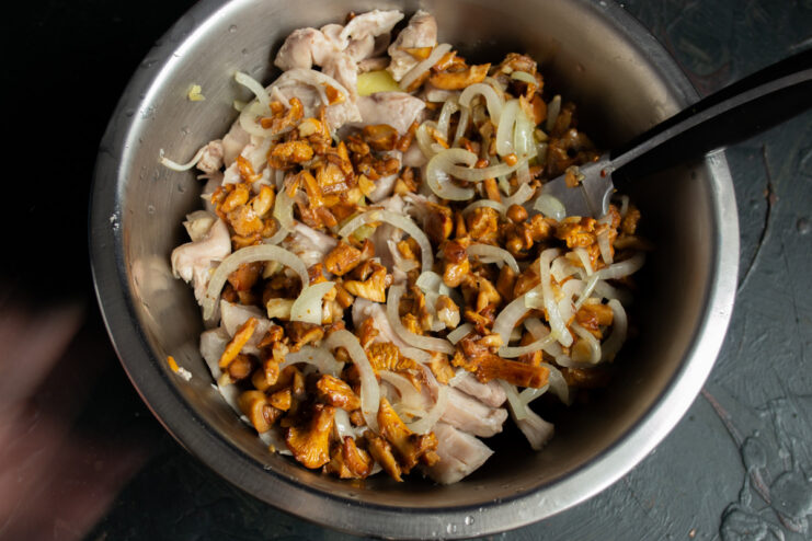 Adding Sautéed Mushrooms and Onions Sautéed chanterelles and onions being added to the salad bowl.