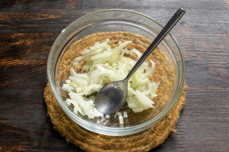 Dicing Sweet Onion for a Flavorful Salsa Base Close-up of a hand dicing a sweet salad onion into small cubes on a cutting board.