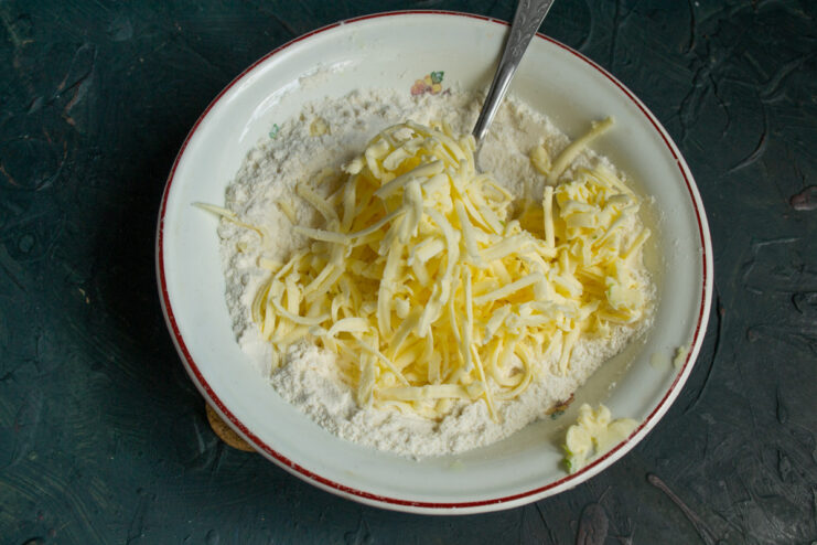 Grating Frozen Butter for a Crumbly Crust Grating a block of frozen butter into the bowl with dry ingredients using a box grater.