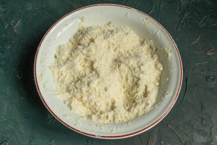 Creating the Perfect Crumble Topping Hands rubbing grated butter into flour mixture to create a sandy, crumbly dough for the pie crust.