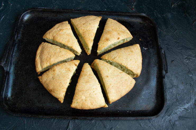 Let the pie cool slightly before slicing it into generous portions. The freshly baked golden-brown zucchini pie being sliced into 8 portions.