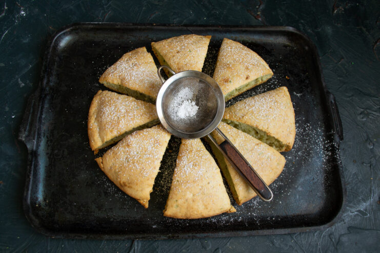 A simple dusting of powdered sugar is the perfect finishing touch for this zucchini pie. A finished sweet zucchini pie, sliced and dusted with powdered sugar, ready to be served.