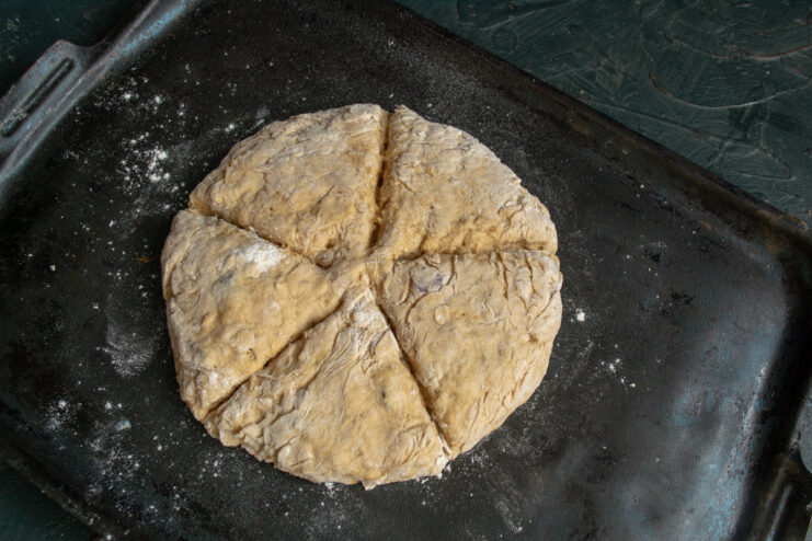 Step 9: Scoring the top of the loaf to allow for even baking. Scoring the top of the soda bread dough with a knife before baking.
