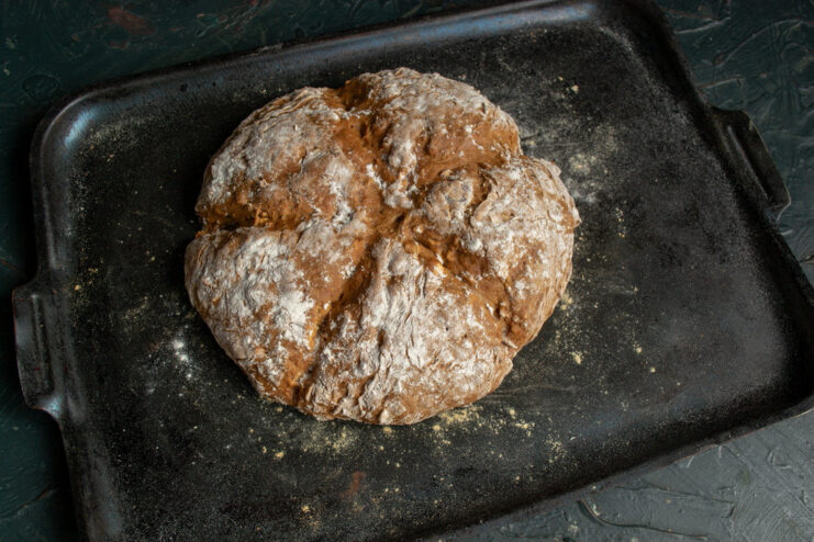 Step 10: Baking the soda bread until golden brown. Placing the baking sheet with the soda bread into a preheated oven.