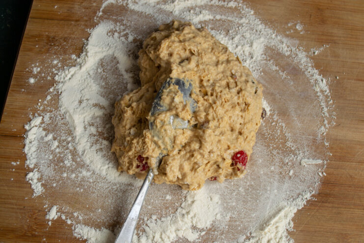 Step 7: Shaping the dough on a floured surface into a round loaf. Shaping the sticky soda bread dough into a round loaf on a floured surface.