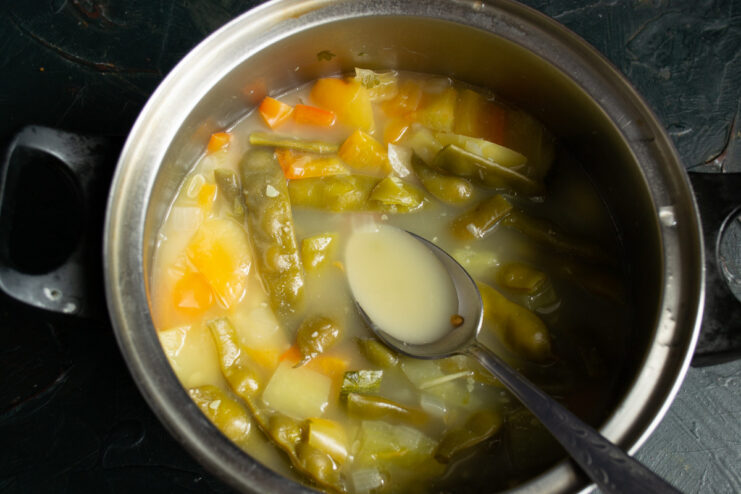 Simmering the Vegetables Until Tender A pot of vegetable soup simmering on the stove.