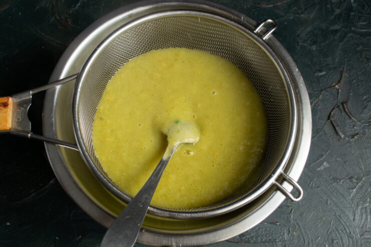 Straining the Soup for an Extra-Smooth Texture Straining the blended vegetable soup through a fine-mesh sieve for a smooth texture.