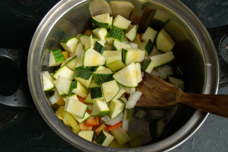 Adding Diced Zucchini to the Vegetable Mix Diced zucchini being added to a pot for the vegetable soup.