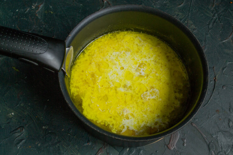 Adding heavy cream to the cooked vegetables. Pouring heavy cream into the pot with cooked vegetables.