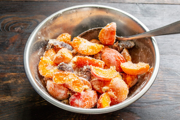 Combining all ingredients for the apricot and date pie filling. A bowl with all the filling ingredients—apricots, dates, walnuts, sugar, and flour—being mixed.