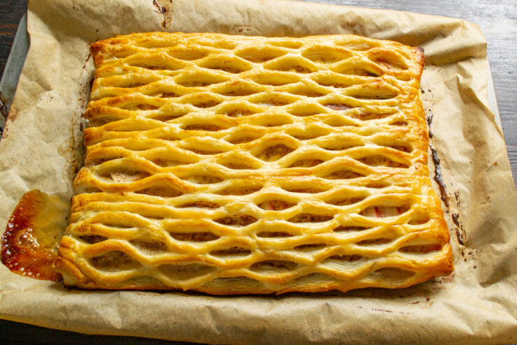 The apple puff pastry pie baking in the oven, turning golden brown.