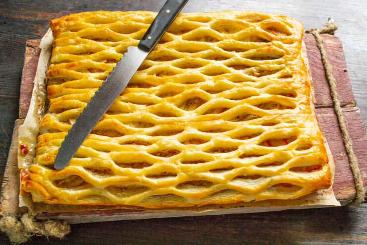 A slice of the warm apple and honey puff pastry pie on a plate, ready to be eaten.