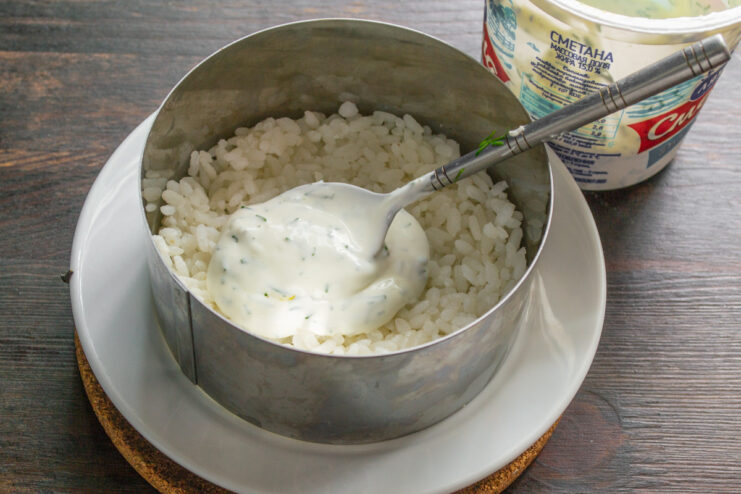 Preparing the Creamy Wasabi Dill Dressing A white bowl with mayonnaise, sour cream, chopped dill, and wasabi being mixed for the salad dressing.