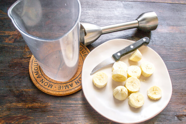 Step 1: Adding a Ripe Banana to the Blender A ripe, peeled banana being placed into a blender cup.