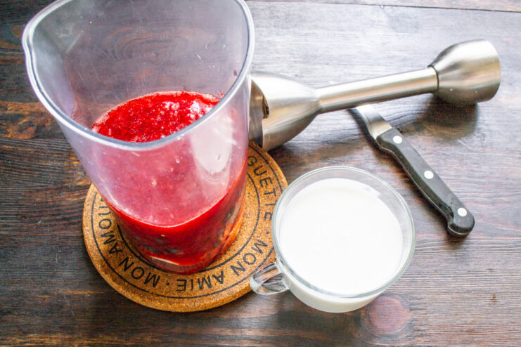 Step 4: Pouring in Kefir for a Creamy, Tangy Base Kefir or yogurt being poured into the blender cup with fruit.