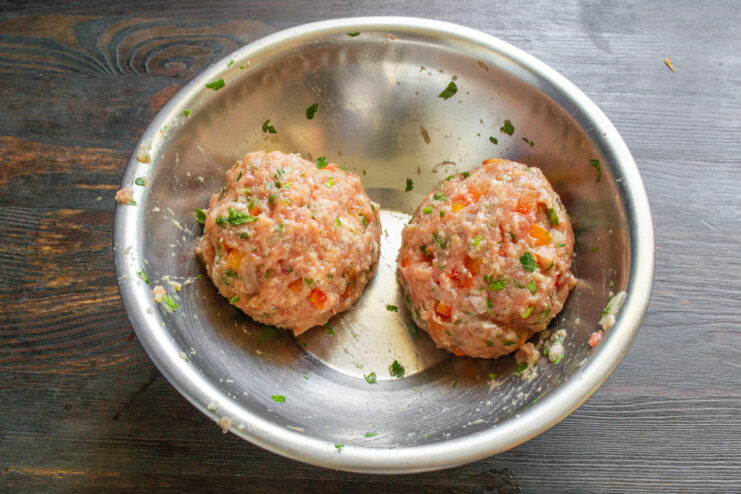 Shaping the Ground Pork into Compact Patties Hands shaping a portion of the ground pork mixture into a patty.