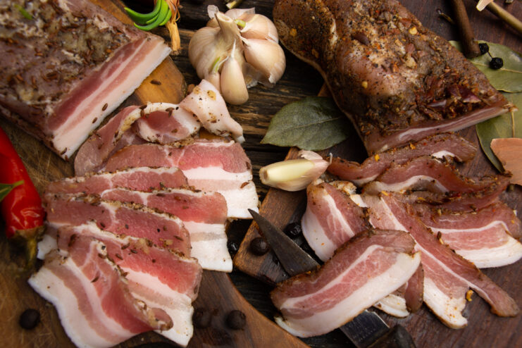 Finished slices of Solonina Kazatskaya, a Cossack-style cured pork belly, arranged on a plate.