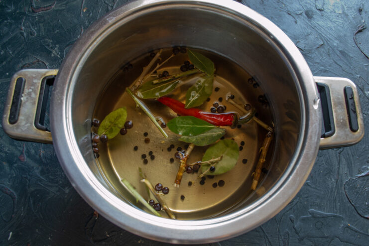 Step 3: Preparing the Aromatic Brine A pot on the stove with water, bay leaves, and peppercorns boiling to create an aromatic brine.